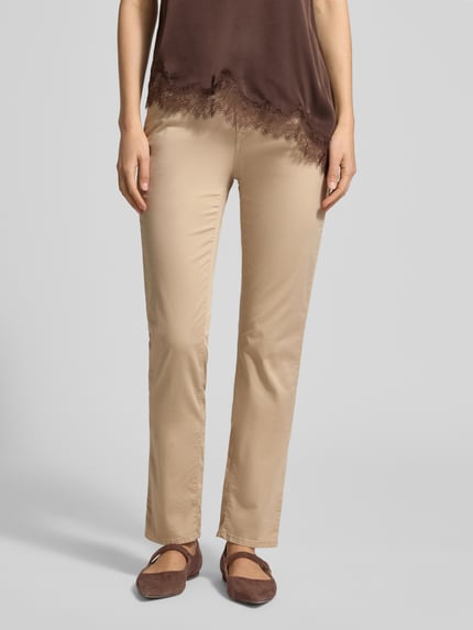 Frauenmodel trägt Hose mit Eingrifftaschen Modell 'Mary' von Brax, beiger Baumwoll-Lyocell-Mix, Regular-Fit, Ganzkörperansicht von vorne.