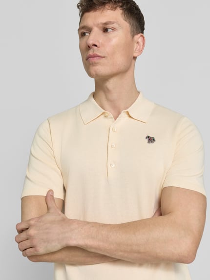 Männermodel trägt Regular Fit Poloshirt mit Knopfleiste von PAUL SMITH aus reiner Baumwolle mit Stitching, Nahaufnahme Oberkörper.
