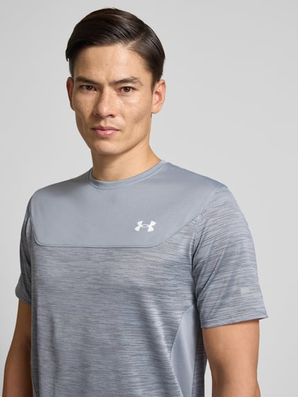 Mannelijk model draagt Funktionsshirt met logo en ronde hals van Under Armour in grijs, regular fit, materiaal-mix met stretch, Nahaufnahme bovenlichaam.