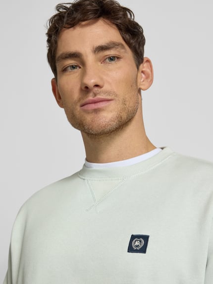 Männermodel trägt Sweatshirt mit Rundhalsausschnitt und Label-Patch von Lerros im Baumwoll-Mix, Relaxed Fit, Nahaufnahme Oberkörper.