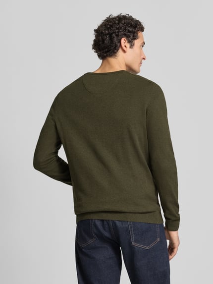 Männermodel trägt Pullover mit Logo-Detail von S.OLIVER CASUAL in Unifarbe, V-Ausschnitt, Feinstrick, Rückansicht Ganzkörperansicht.