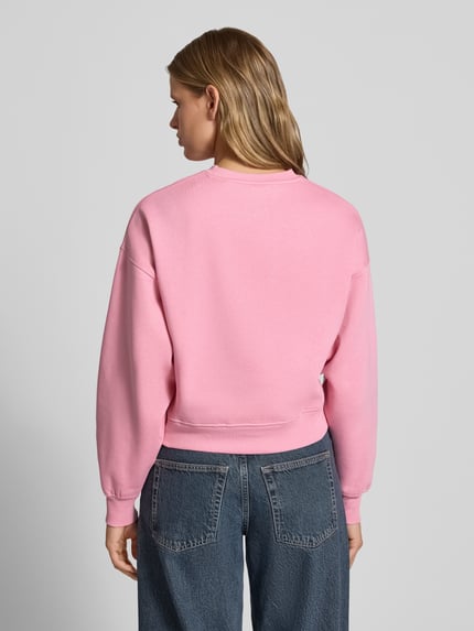 Frauenmodel trägt Relaxed Fit Sweatshirt aus Baumwoll-Mix Modell 'Tatum' von JJXX in Rosa, gerippte Bündchen, Rückenansicht, Ganzkörperansicht Rückansicht.
