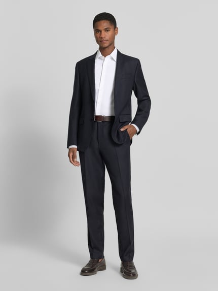 Męski model nosi Slim Fit Businesshemd aus reiner Baumwolle Modell 'HANK' von BOSS, jednokolorowy, kołnierzyk typu kent, długi rękaw, popelina, bawełna, naszywka z logo, zaokrąglone wykończenie, sportowy mankiet, listwa guzikowa na całej długości, zapięcie na guzik, Ganzkörperansicht von vorne.