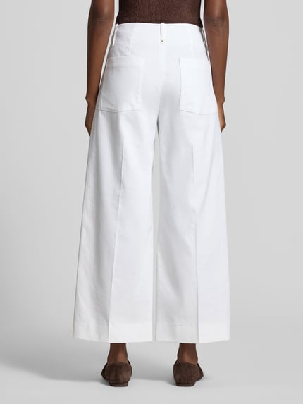 Frauenmodel trägt Wide Leg Hose mit Längsnähten von Luisa Cerano aus Baumwoll-Viskose-Mix mit Eingrifftaschen, weiß, Ganzkörperansicht Rückansicht.