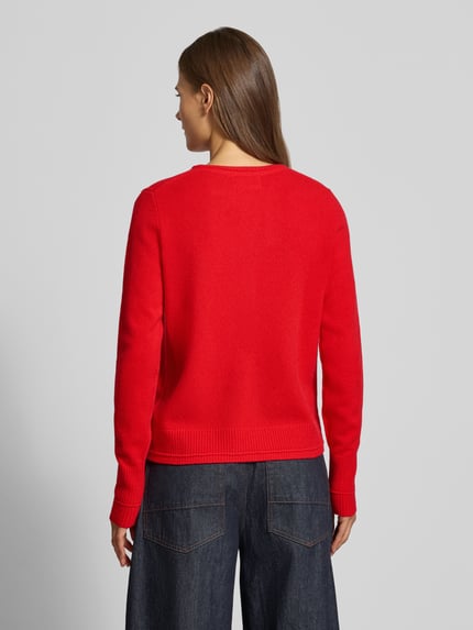 Frauenmodel trägt roten Cardigan aus Wolle mit Rundhalsausschnitt von Christian Berg Woman, strukturierte Oberfläche, Ganzkörperansicht Rückansicht. Rückenlänge bei Größe S 58 cm, Ärmellänge 63 cm, Regular Fit.