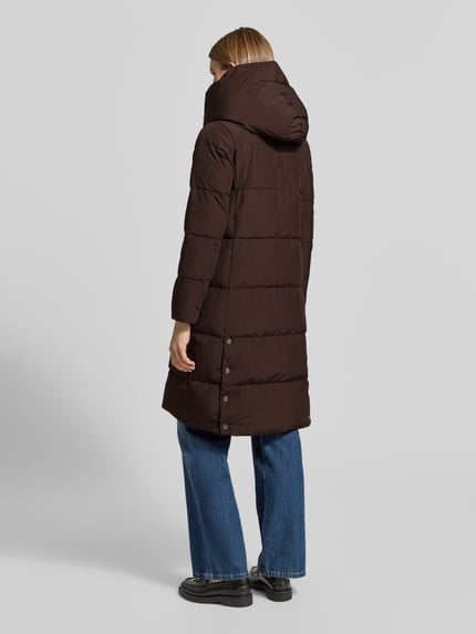 Frauenmodel trägt Regular Fit Daunenmantel mit Zweiwege Reißverschluss von LAUREN RALPH LAUREN in Unifarbe Braun, Longline-Länge, gesteppte Struktur, langarm mit elastischem Ärmelabschluss, seitliche Eingrifftaschen, Ganzkörperansicht Rückansicht.