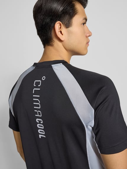 Męski model nosi T-Shirt mit Label-Print od adidas Training, czarne z szarymi wstawkami, regular fit, zdjęcie z tyłu, całkowita sylwetka.