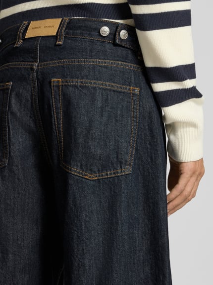 Männermodel trägt Wide Fit Jeans aus reiner Baumwolle Modell 'TIMOTHY' von Samsøe Samsøe, dunkles Denim, 5-Pocket-Design, Nahaufnahme Rückansicht. Reine Baumwolle, Knopf- und Reißverschluss, Gürtelschlaufen, Bundweite 43 cm, Innenbeinlänge 72 cm.
