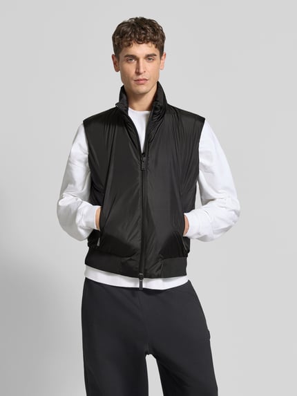 Männermodel trägt schwarze Weste mit Zweiwege-Reißverschluss von Dsquared2, Stehkragen, gerippter Bund, Ganzkörperansicht von vorne.