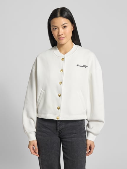 Vrouwenmodel draagt Relaxed Fit Sweatjacke aus Baumwoll-Mix van Tommy Hilfiger in effen wit, lange mouwen, label-stiksel, geribde boorden, zijkzakken, katoenmengsel, ganzkörperaanzicht van voren.