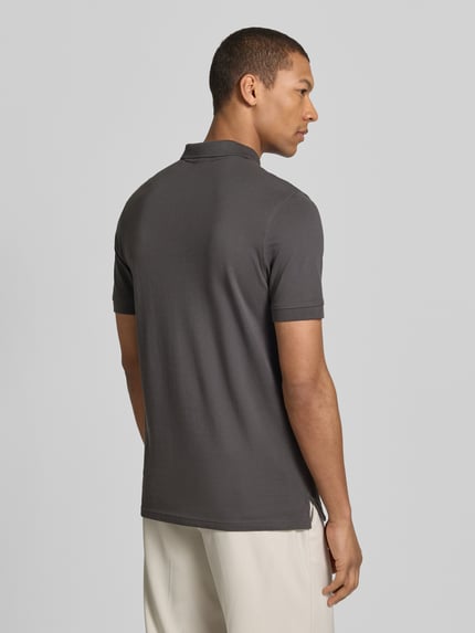 Męski model nosi Regular Fit Poloshirt mit Stitching von Christian Berg Men z bawełny, krój regular fit, listwa guzikowa, haft, długość tyłu 70 cm, widok całej sylwetki z tyłu.