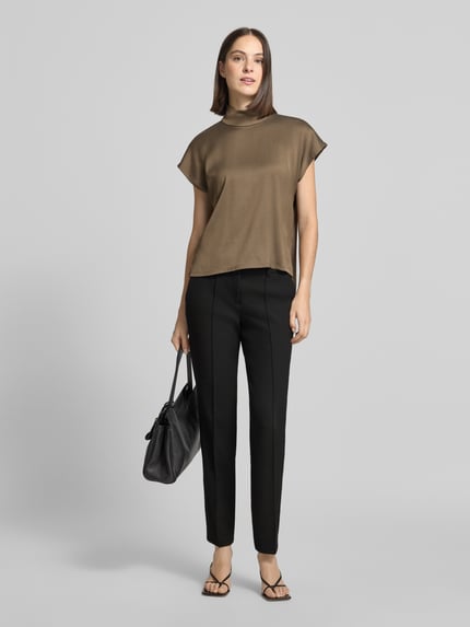 Frauenmodel trägt Slim Fit Hose aus Webware mit Bügelfalten Modell 'SARAH' von CAMBIO in Schwarz, kombiniert mit braunem Oberteil, Damen Schmale Hose von CAMBIO, Ganzkörperansicht von vorne.
