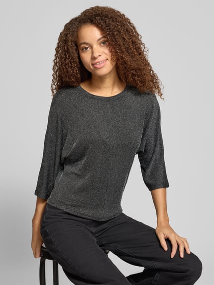 Frauenmodel trägt Langarmshirt mit glänzender Optik von ONLY, dunkle Farbe, Jersey, Rundhals, 3/4-Arm, Ganzkörperansicht von vorne.