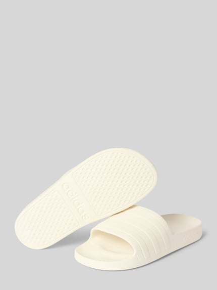 Produktfoto, Badeschuhe mit Label-Prägung Modell 'ADILETTE AQUA' von adidas, Optik: Unifarben, flach, Schlupf/offen, Signature-Streifen, strukturierte Textur