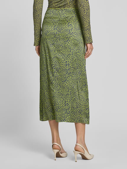 Vrouwenmodel draagt Midirok uit Viskose-Mix met Seiden-Anteil van Marc Cain, all-over dierenprint in groen, lichte A-lijn, naadritssluiting, bandwijdte maat 36: 37 cm, totale lengte maat 36: 81 cm. Ganzkörperansicht Rückansicht.