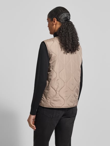 Frauenmodel trägt Regular Fit Steppweste mit einreihiger Knopfleiste Modell 'MILLIE' von Vero Moda, Optik: Unifarben, Rückansicht.