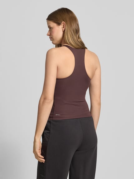 Frauenmodel trägt Slim Fit Top mit integriertem Bustier von PUMA, krój slim fit, elastyczny materiał, logo, bez rękawów, okrągły dekolt, brązowy, długość pleców 44 cm w rozmiarze S, widok całej sylwetki z tyłu.