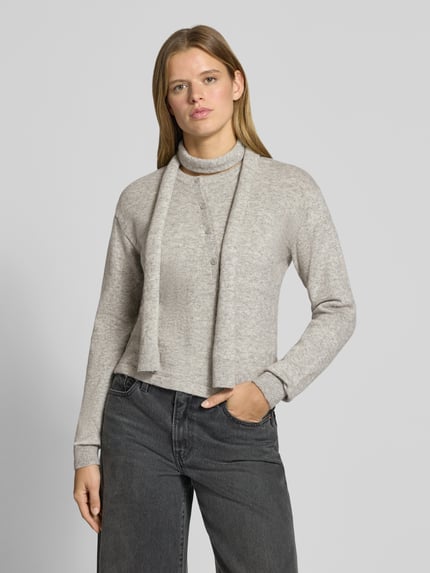 Vrouwenmodel draagt Regular fit gebreid jack uit elastische wolmix Model 'JANE' van JJXX, knoopsluiting, ruglengte maat S 54 cm, mouwlengte maat S 61 cm, grijs, eenvoudige structuur, zachte textuur, voorkant bovenlichaam close-up.