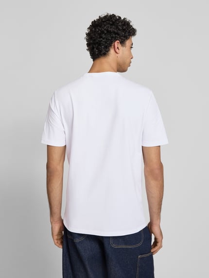 Męski model nosi Regular Fit T-Shirt-Set aus Baumwoll-Mix Modell 'NAOLO' im 2er-Pack od HUGO Blue, biały, krój regular fit, koszulka z bawełnianej dzianiny, gładka, nadruk z logo, krótki rękaw, widok całej sylwetki od tyłu.