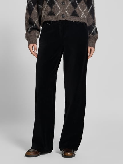 Frauenmodel trägt Regular Fit Cordhose mit Bundfalten Modell 'MAINE' von BRAX in Unifarbe, Cordstruktur, Ganzkörperansicht von vorne.