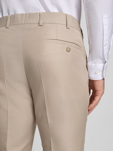 Männermodel trägt Anzughose mit Bügelfalte und Eingrifftaschen van Wilvorst in beige materiaalmix met wol, straight fit, detailaufnahme Gesäßleistentasche.