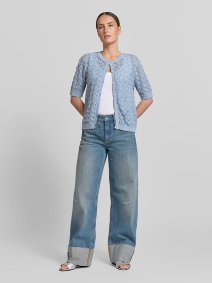 Frauenmodel trägt Regular Fit Strickjacke aus reiner Baumwolle Modell 'SOFIA' von Selected Femme in Hellblau, Ajour-Strick, Ganzkörperansicht von vorne.