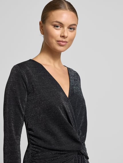 Frauenmodel trägt schimmernden Jumpsuit mit Knotendetail von Milano Italy in Schwarz, V-Ausschnitt, Regular Fit, Nahaufnahme Oberkörper.
