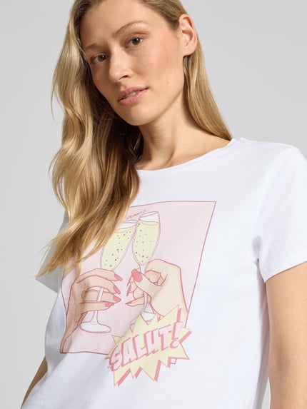 Vrouwenmodel draagt T-Shirt uit zuiver katoen model 'CLINK EASY TEE' van Guess, rechte fit, ronde hals, witte stof, close-up bovenlichaam.