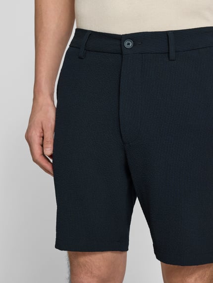 Männermodel trägt Regular Fit Bermudas mit Viskose-Anteil Modell 'KANE1' von BOSS, Melange-Optik, gestreift, Nahaufnahme Oberschenkel.