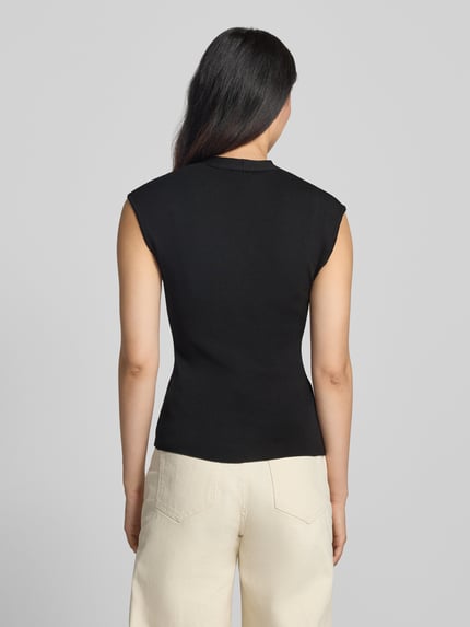 Frauenmodel trägt Stricktop mit V-Ausschnitt Modell 'CANELONS' von MANGO, Schwarz, taillierter Schnitt, Viskose-Mix, Ganzkörperansicht Rückansicht.