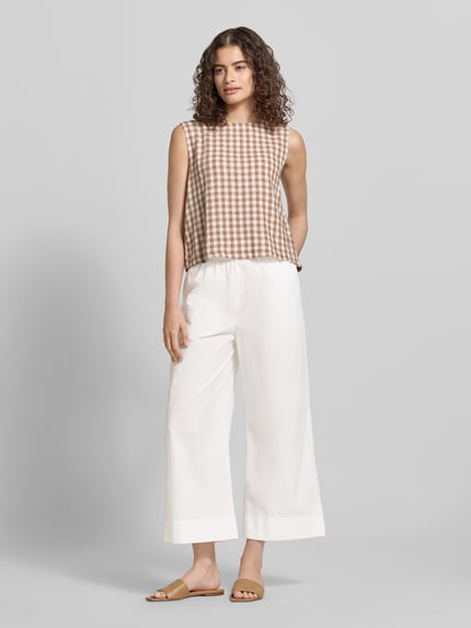 Frauenmodel trägt Relaxed Fit Culotte aus reiner Baumwolle von Marc O'Polo Denim, Optik: Unifarben, Passform: Relaxed-Fit, Länge: Cropped, Bundabschluss: Elastisch, Seitliche Eingrifftaschen, Material: Reine Baumwolle, Farbe: Weiß, fließende Stoffstruktur, Ganzkörperansicht von vorne.
