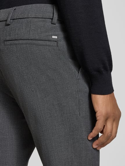Männermodel trägt Regular Fit Schmale Hose mit Viskose-Anteil Modell 'GABARDINE' von BOSS, grauer Stoff, feine Struktur, Nahaufnahme Hüfte. Herren Schmale Hose von BOSS