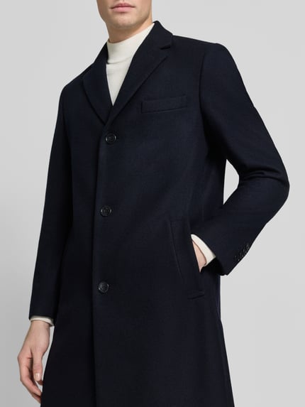 Männermodel draagt Slim Fit Mantel met Reverskraag van HECHTER PARIS in donkerblauwe wolmix met knoopsluiting en steekzakken, Nahaufnahme Oberkörper. Context: Heren lange jas van HECHTER PARIS, wolmix, slim fit, reverskraag, knoopsluiting, steekzakken, ruglengte bij maat 50: 98 cm, schouderbreedte bij maat 50: 45 cm, borstwijdte bij maat 50: 54 cm, mouwlengte bij maat 50: 68 cm.