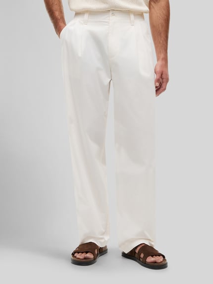 Männermodel trägt Loose Fit Hose met bandplooien van Tommy Hilfiger in effen kleuren, puur katoen, steekzakken, klepzak, knoopsluiting, Ganzkörperansicht van voren.