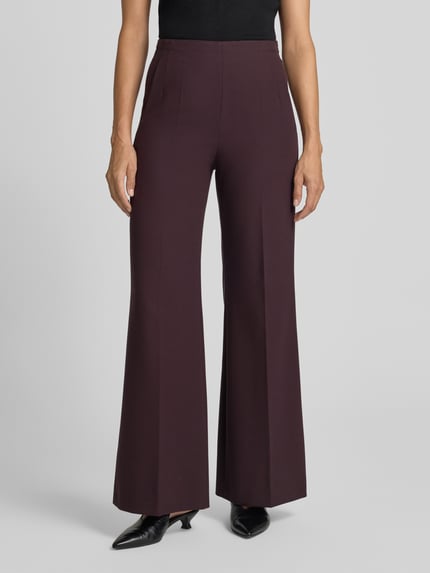Frauenmodel trägt Flared Fit Hose mit Viskose-Anteil von windsor, dunkelbraun, elastischer Bund, Bügelfalten, Ganzkörperansicht von vorne.