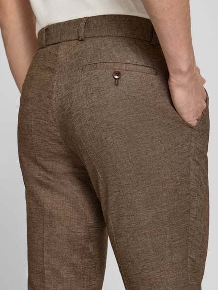 Männermodel trägt Anzughose aus linnenmix Modell 'Tomte' van Carl Gross, met stretch, persplooien, achterzakken, slim fit, detailaufnahme.
