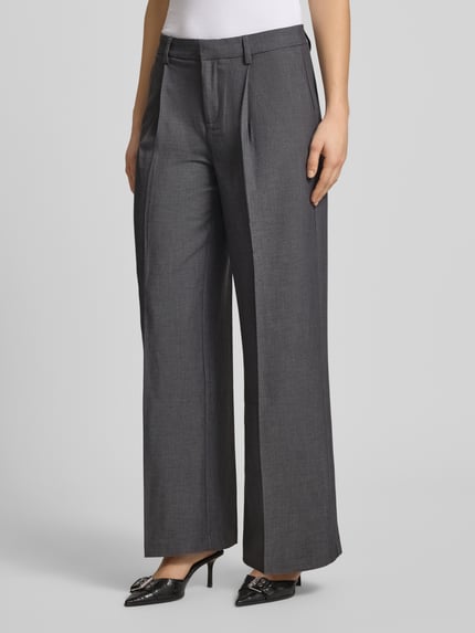 Frauenmodel trägt Wide Fit Stoffhose mit Viskose-Anteil von Gina Tricot, dunkelgrau, Bügelfalten, elastischer Material-Mix, Nahaufnahme Oberkörper.