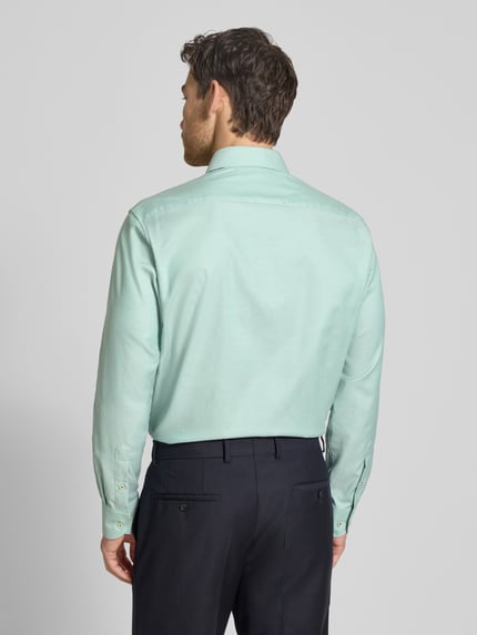 Männermodel trägt Regular Fit Business-Hemd mit Kentkragen von ETERNA in Mint, Reine Baumwolle, Langärmelig, Sportmanschetten, Ganzkörperansicht Rückansicht.