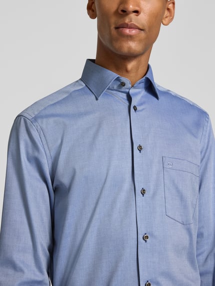 Männermodel trägt hellblaues Modern Fit Businesshemd aus reiner Baumwolle von OLYMP mit feiner Struktur, Nahaufnahme Oberkörper, Herren Businesshemd von OLYMP.