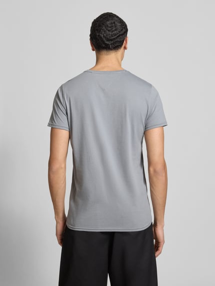 Męski model nosi Regular Fit T-Shirt aus reiner Baumwolle von Tommy Jeans, efekt: jednolity kolor, krój regular fit, wyhaftowane logo, okrągły dekolt, krótki rękaw, bawełna, całkowity widok z tyłu