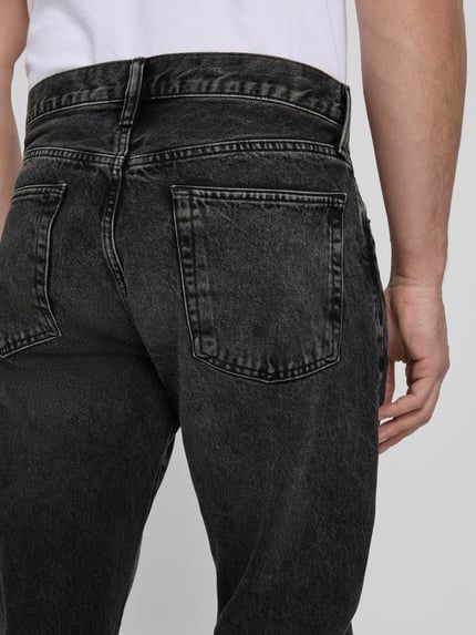 Mężczyzna nosi Relaxed Straight Fit Jeans im Used-Look od GAP, czarne odcienie, wpuszczane kieszenie, bawełna, efekt znoszenia, długość wewnętrzna nogawki 80 cm, szerokość w rozmiarze 32/32: 44 cm, detal tylnej kieszeni, zbliżenie na górną część nóg, widok z tyłu
