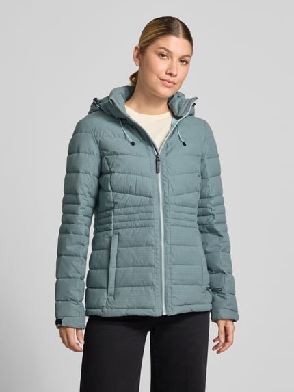 Frauenmodel trägt Jacke mit Kapuze und Label-Patch Modell von G.I.G.A. DX in Hellblau, gesteppte Textur, Ganzkörperansicht von vorne.