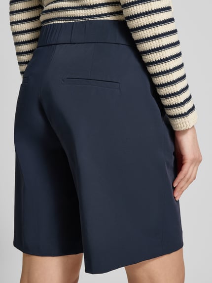 Frauenmodel trägt Schlupfbermuda Techno Cotton Superstretch von Raffaello Rossi, dunkelblau, Regular-Fit, Modell ISKA, Gesäßtaschen, elastischer Bund, Detailaufnahme Rückansicht.