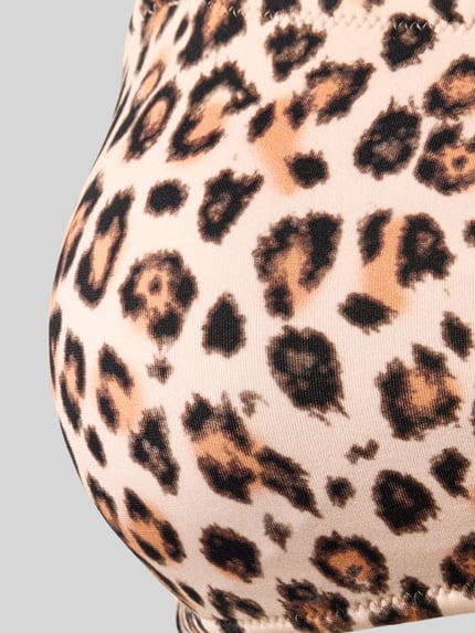 Frauenmodel trägt Bikini-Oberteil mit Schnürung Modell 'NILO SAVARI' von Banana Moon, Material-Mix mit Stretch-Anteil, Leopardenmuster, körpernahe Passform, Bandeau-Form, Detailaufnahme.