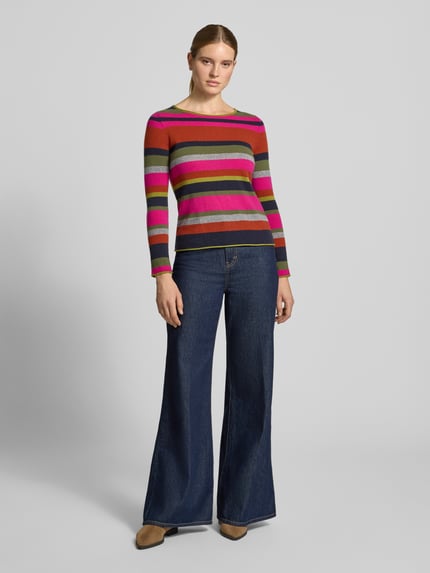Frauenmodel trägt Regular Fit Longsleeve aus reinem Kaschmir von Christian Berg Woman, bunt gestreift, Strick-Optik, Rundhalsausschnitt, kombiniert mit blauer Jeans, Ganzkörperansicht von vorne.