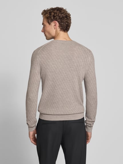 Männermodel trägt Wollpullover mit Struktur-Muster Modell 'Connor' von Tiger of Sweden in Beige, reine Wolle, gerade Form, Ganzkörperansicht Rückansicht.