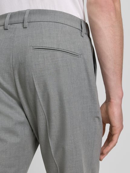 Männermodel trägt Anzughose mit Bügelfalten Modell 'AJEND' von Drykorn, grauer Material-Mix mit Woll-Anteil, Regular-Fit, Detailaufnahme Rückansicht.
