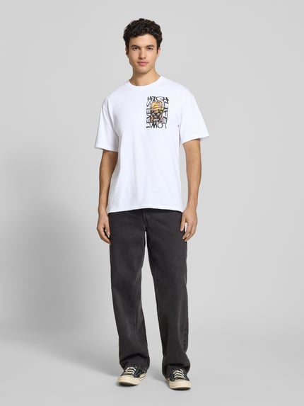 Mannenmodel draagt wit T-shirt met print model 'HATTY MAN' van Edwin, puur katoen, relaxed fit, ronde hals, ruglengte maat M 73 cm, geheel lichaamsbeeld van voren.