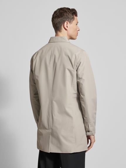 Männermodel trägt Kurzmantel mit verdeckter Knopfleiste Modell 'miles' von Matinique in Beige, glatte Textur, Ganzkörperansicht Rückansicht. Regular Fit, Umlegekragen, dezentes Design.