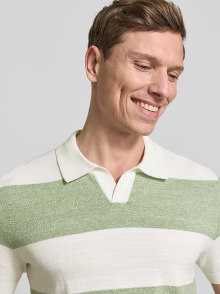 Männermodel trägt Slim Fit Poloshirt aus Baumwoll-Mix in Strick-Optik von OLYMP Level Five, grün-weiß gestreift, Nahaufnahme Oberkörper.
